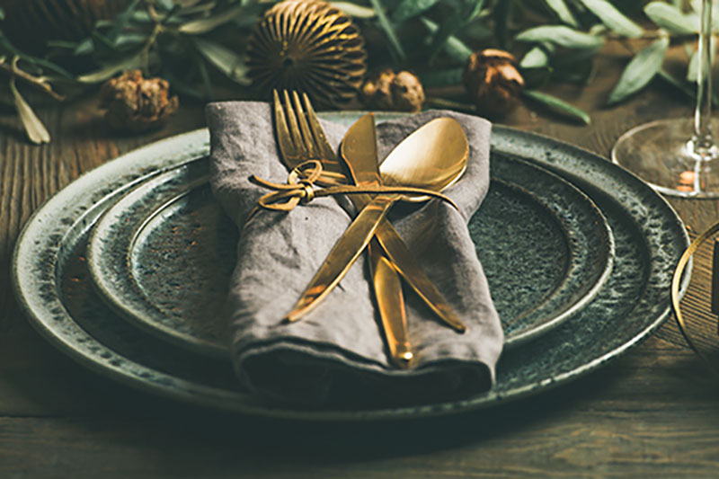 Holiday Party Silverware Set Piece A set-piece prepared by event production company for a holiday party. Holiday color palettes are displayed with the dinner set piece on a wooden table.